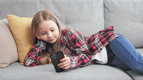 Girl Relaxing on Sofa with Smartphone