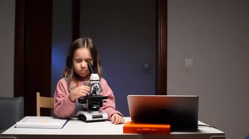 Little Girl Exploring Microworld with Microscope During Science Lesson