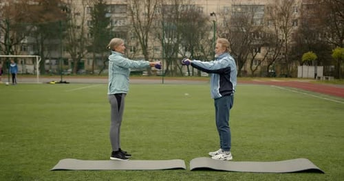 Couple of Senior People Exercise Outdoors on a Stadium