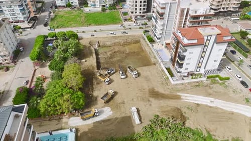 Groundbreaking Aerial of Excavators and Trucks Clearing Soil