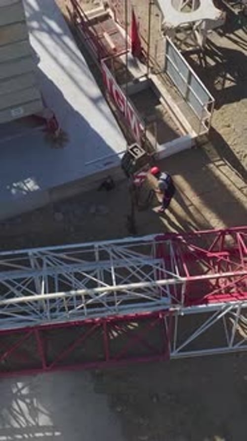 Vertical Video Construction Workers Building A Tower Crane With Precision On A Large Construction
