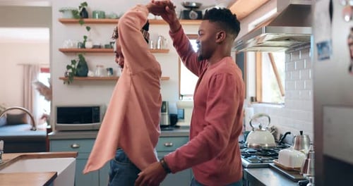 Happy Young Couple Dancing and Hugging in Kitchen