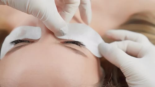 O cliente fica relaxado e confortável durante o delicado processo de extensão dos cílios Beautiful Woman at