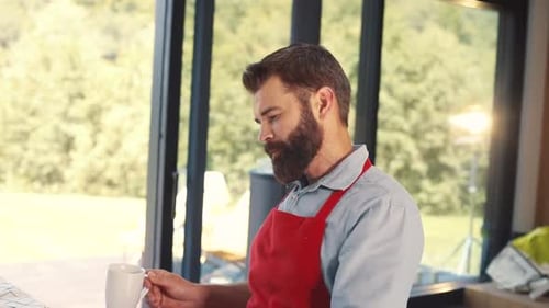 Handsome Man with Beard Holding White Cup in Hand Drinking Tea Pleasantlooking Caucasian Man in Red
