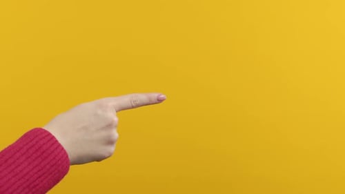 Hand Pointing Left on Yellow Background
