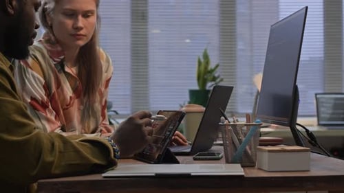 Coworkers de la génération Z programmant des codes sur des appareils numériques au bureau