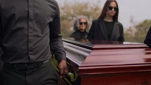Pallbearers Carry Casket at Outdoor Funeral Service