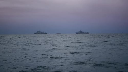 Ships Silhouetted on Ocean Horizon at Dusk