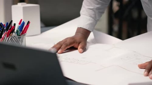 African American Contractor Examine Architectural Blueprints Plans on Table