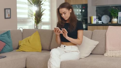 Woman reacts to phone with joyful emotion