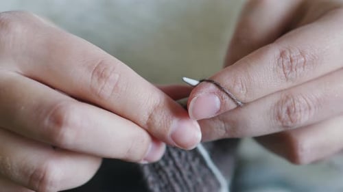 Hands Knitting Yarn with Silver Needles Close Up