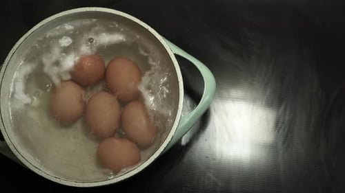 Eier werden in einem Topf mit kochend heißem Wasser mit etwas Schaum darüber gekocht. Hartgekochte Eier (top v
)