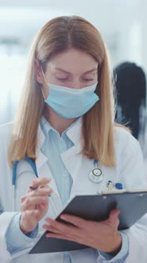 A Medical Professional Working in a Clinic is Diligently Writing Important Notes