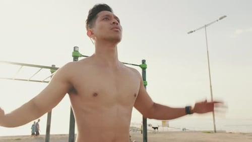 Close up, young athletic man does a warm-up, training the leg muscles, jumping jacks