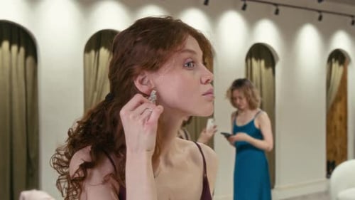 Woman Tries on Earrings in Upscale Fashion Boutique