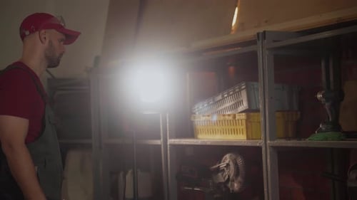 A Man Enters the Workshop and Turns on a Lamp Illuminating the Workspace He Begins to Lay Out Tools