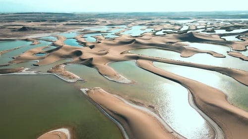 Aerial Shot of Oasis Amidst Desert Dunes