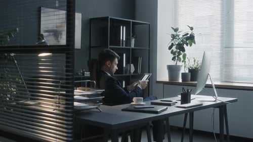 Director Using Digital Tablet at Workplace in Office