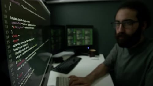 Man Having Intense Coding Session in Dimly Lit Programmer Workspace