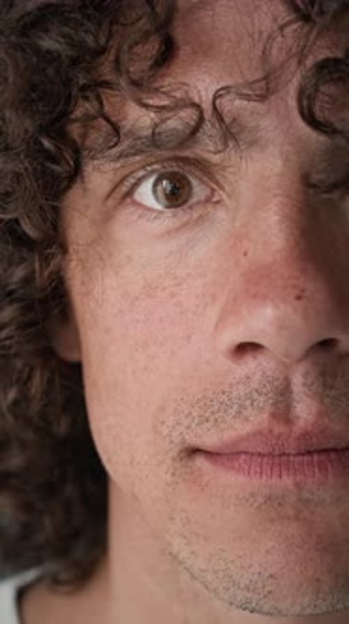 Half Face Close Up Portrait of Handsome Young Man with Curly Brown Hair