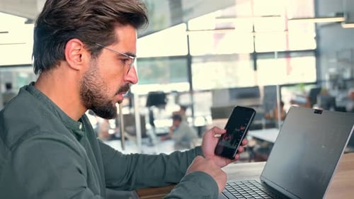 Investor Holding Phone Using Laptop Analyzing Stock Trade Market Data
