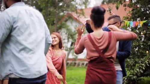 Happy friends dancing groovy at summer garden party in slow motion