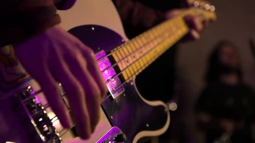 Strumming bass guitar strings in slow motion