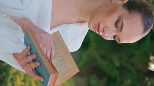 Romantic Lady Reading Novel on Go at Park Closeup Woman Turning Pages Vertical