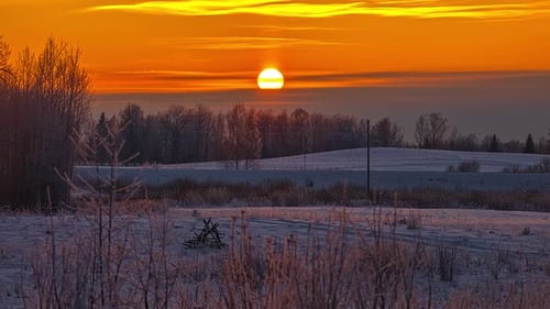 beautiful orange sunset timelapse background, on snowy countryside meadow