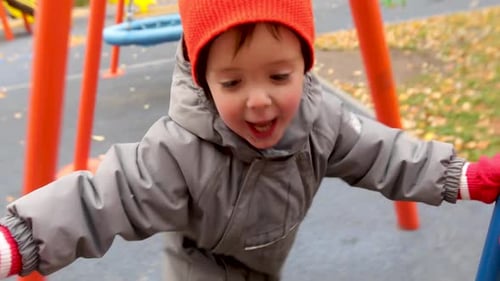 Un niño hace girar un carrusel en otoño