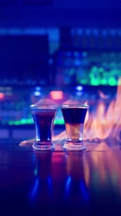 Glass of Alcoholic Drink on Fire on a Bar Counter Closeup in a Nightclub