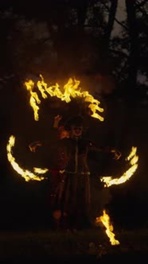 Mystical Nighttime Fire Dancing Performance with Traditional Costume Swirling Flames and Dynamic