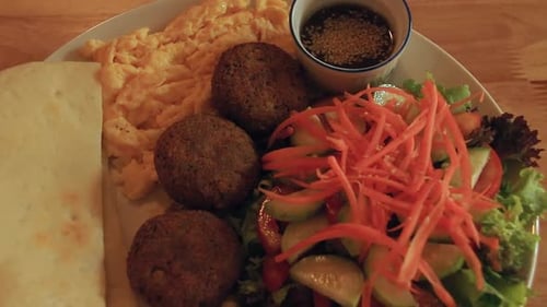 Pull out view of a plate full of high protein ovo-vegetarian ketogenic breakfast consisting of falaf
