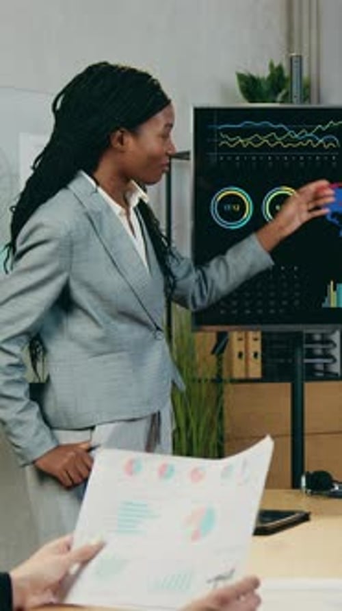 Woman Presenting Financial Data in Modern Office