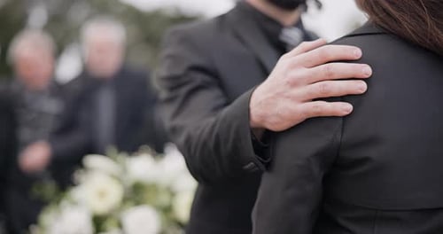 Man Comforts Woman at Funeral with Support