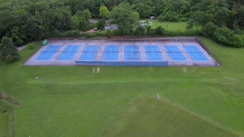 Aerial View of Blue Tennis Courts Surrounded by Green