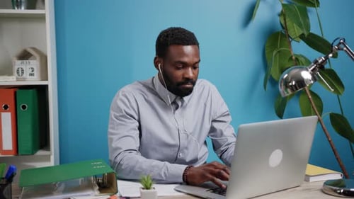 A Professional Focused on Their Laptop in a Contemporary Office Environment Space