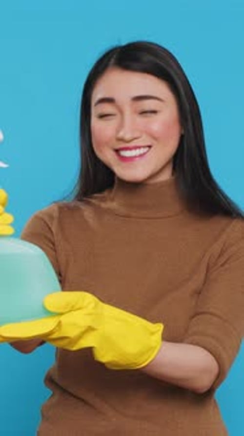 Vertical Video Smiling Asian Maid Wearing Protective Gloves While Showing Chemical Detergent Spray