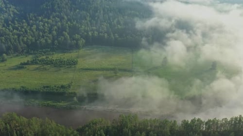 Majestic Clouds Drifting Above a Lush Forest and Meandering River