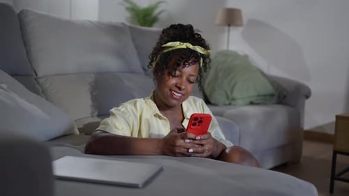 Woman Using Smartphone on Couch at Home