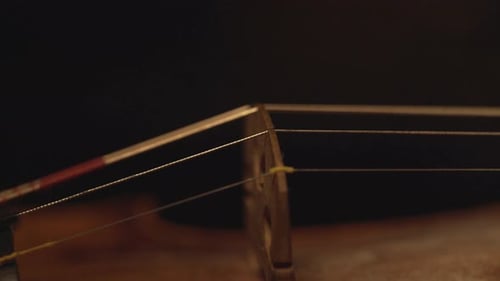 close up of old violin, dramatic light changes over the instrument , classical symphony music video