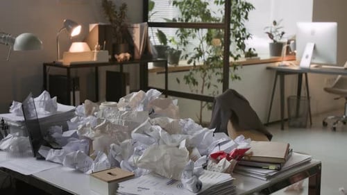 Office Desk Covered with Pile of Crumpled Paper Documents