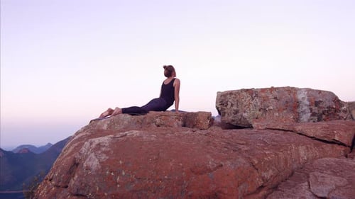 Serene yoga practice at sunset on a mountain overlooking a lake in breathtaking nature