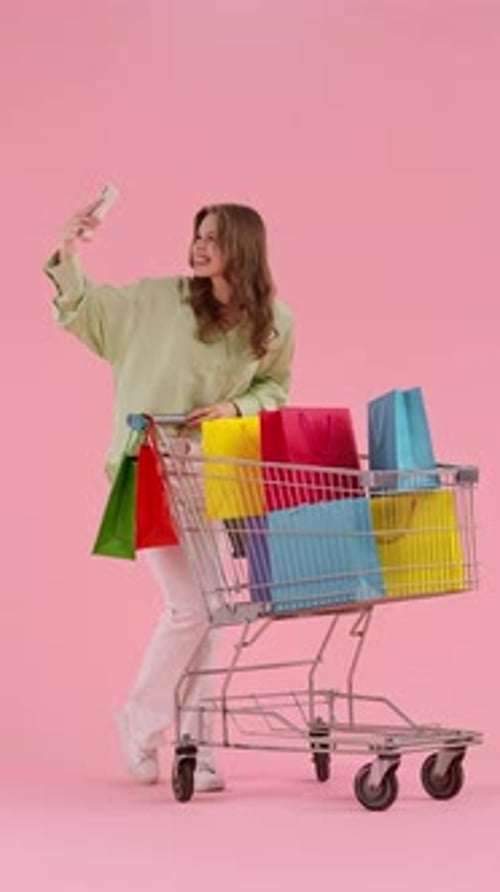 Woman in Green Shirt Shopping with Cart Full of Colorful Bags