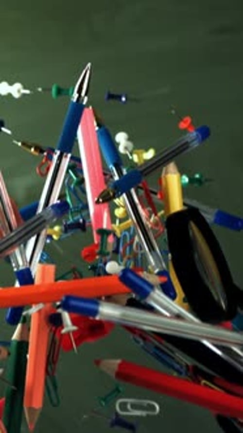 Different School Objects Fly and Fall Against the Background of the Blackboard Filmed on a Highspeed