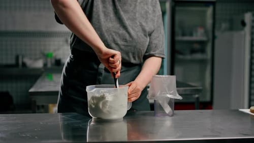 Close Up Female Baker in Professional Kitchen Transfers Cream Paste Into a Pastry Bag