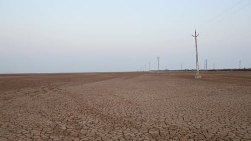 dry cracked farm fields with bright sky at morning