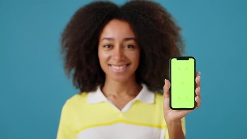 Black Woman Demonstrates Cellphone with Blank Green Screen