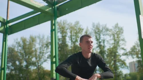 Man Stretching in Green Urban Fitness Structure