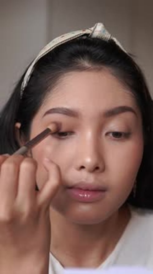 Woman Applying Eye Shadow to Eyelid with Brush
